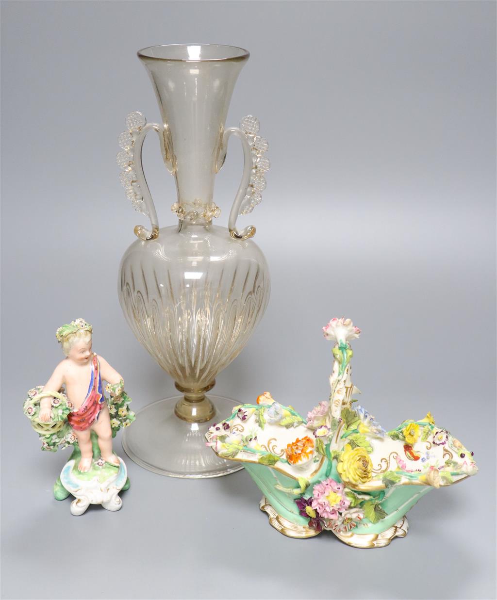 A Coalbrookdale floral encrusted basket, a Bow porcelain putto and a Venetian two handled glass vase, 28.5cm (3)